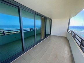Honolulu condo for rent - A balcony with glass doors overlooking the ocean.
