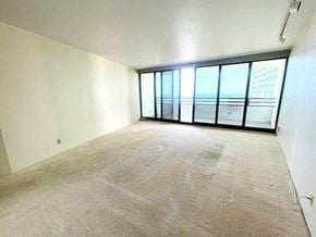 Honolulu condo for rent - A room with a carpeted floor and large windows.