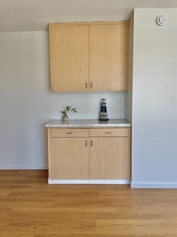 Honolulu condo for rent - A kitchen with wooden cabinets and a white fridge.