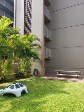 Honolulu apartment for rent - a piece of art sits on the grass in front of a building