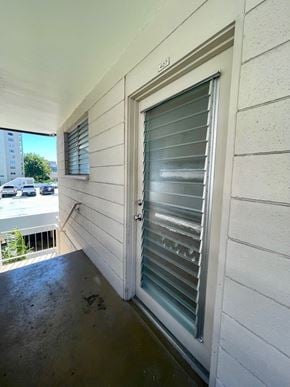 Honolulu condo for rent - A white door with a window on the side of a building.