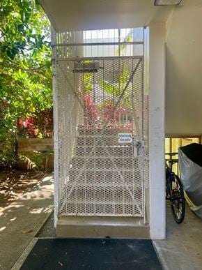 Honolulu condo for rent - A metal gate with a keypad lock is open.
