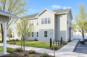 South Burlington apartment for rent - A grey house with a white porch and a tree in front.