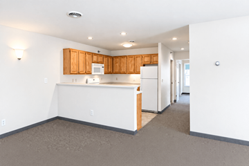South Burlington apartment for rent - A kitchen with white appliances and wooden cabinets.