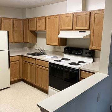 Burlington apartment for rent - a kitchen with wooden cabinets and a stove and a sink