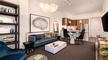 San Diego apartment for rent - A modern living room with a blue couch and a grey abstract painting on the wall.