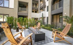 Laguna Niguel apartment for rent - A patio with chairs and a fire pit in front of a building.
