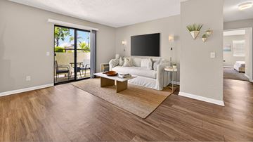 San Marcos apartment for rent - A living room with a white couch and a flat screen TV mounted on the wall.