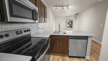 Portland apartment for rent - A modern kitchen with a stove top oven and microwave.