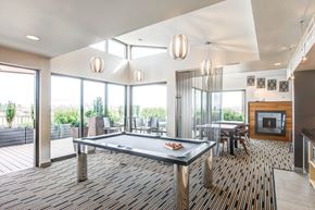 Seattle apartment for rent - A pool table is in the middle of a room with a wood floor and a fireplace.