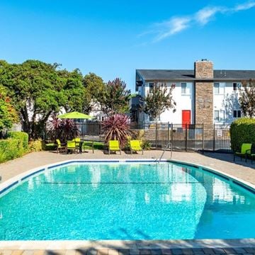San Leandro apartment for rent - A swimming pool in front of a white building with a red door.