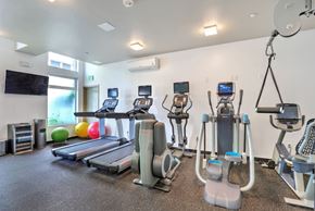 Seattle apartment for rent - A gym with a variety of equipment including treadmills, elliptical machines, and weight machines.