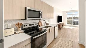 Seattle apartment for rent - A modern kitchen with a white countertop and a black stove.