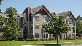 West Linn apartment for rent - A large, multi-story residential building with a mix of beige and brown exterior walls.