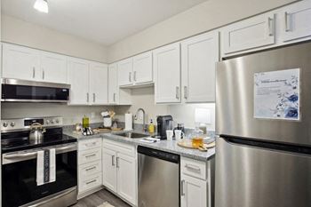 A kitchen with stainless steel appliances and white cabinets