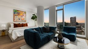 Los Angeles apartment for rent - a bedroom with a bed and a large window and a blue couch
