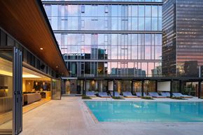 Los Angeles apartment for rent - A modern building with a pool and lounge chairs.