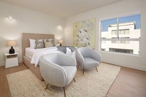 Los Angeles apartment for rent - A bedroom with a large bed and two chairs.