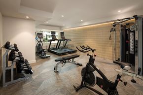 Los Angeles apartment for rent - A home gym with a variety of equipment including a rowing machine, treadmill, and weights.
