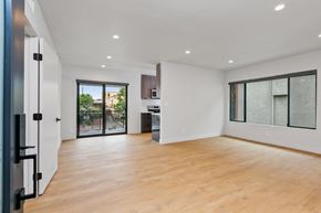 Los Angeles apartment for rent - a living room with white walls and a sliding glass door to a kitchen