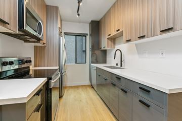 Los Angeles apartment for rent - a kitchen with white counters and wooden cabinets and a stainless steel refrigerator