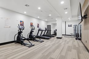Tulsa apartment for rent - A gym with treadmills, elliptical machines, and a flat screen TV.