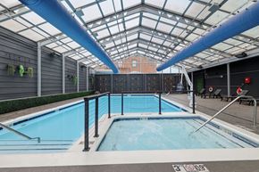 Tulsa apartment for rent - A large indoor pool with a glass ceiling and a blue pipe running along the top.