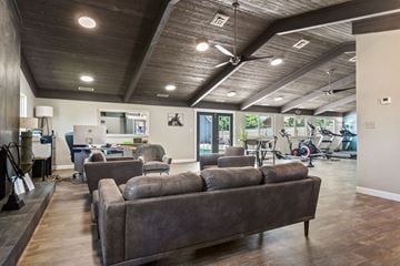 Wichita apartment for rent - A living room with a grey couch and a ceiling fan.