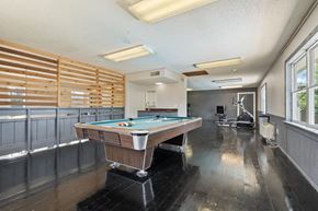 Wichita apartment for rent - a game room with a pool table and a gym with a wheelchair