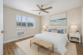 Naples apartment for rent - A bedroom with a large bed, a ceiling fan, and a painting on the wall.