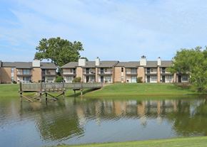 Stillwater apartment for rent - A row of houses with a bridge over a pond in front.