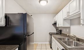 Port Royal apartment for rent - A kitchen with a black refrigerator and white cabinets.