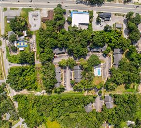 Port Royal apartment for rent - A bird's eye view of a residential area with houses, trees, and a swimming pool.