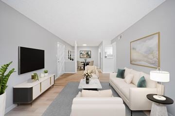 Port Royal apartment for rent - A modern living room with a white sofa, a grey rug, and a large painting on the wall.