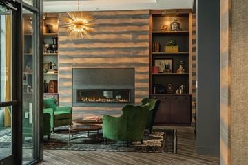 Beverly apartment for rent - a living room with green chairs and a fireplace