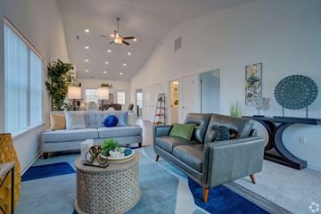 Howell apartment for rent - A living room with a grey couch and a round table.