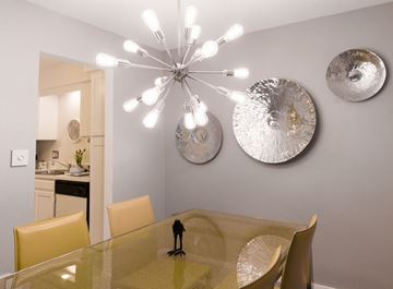 Kentwood apartment for rent - A dining room with a glass table and chairs and a chandelier.