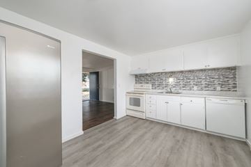 Lakewood apartment for rent - A kitchen with white cabinets and a stone backsplash.