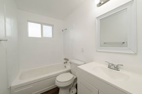 Lakewood apartment for rent - A white bathroom with a toilet, sink, and bathtub.