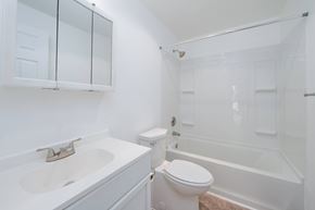 Tacoma apartment for rent - A white bathroom with a toilet, sink, and bathtub.