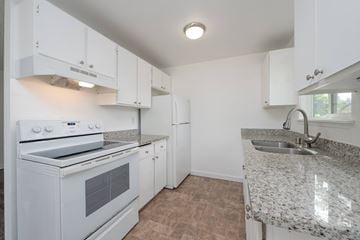 Tacoma apartment for rent - A kitchen with white cabinets and a granite countertop.