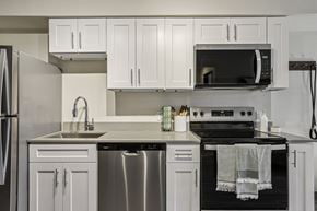 Gresham apartment for rent - A modern kitchen with white cabinets and stainless steel appliances.