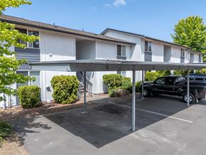 Tacoma apartment for rent - A black truck is parked in a parking lot under a covered area.