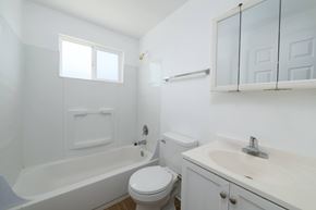Lakewood apartment for rent - A white bathroom with a toilet, sink, and bathtub.