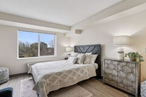 Gresham apartment for rent - A bedroom with a large bed and a window overlooking trees.