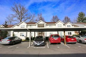 Gresham apartment for rent - A parking lot with cars parked in front of a white building.
