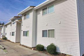 Gresham apartment for rent - A row of houses with white siding and small front yards.