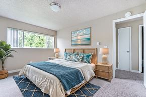 Mukilteo apartment for rent - A bedroom with a large bed and a painting on the wall.