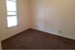 Seattle apartment for rent - an empty room with a window and a brown carpet