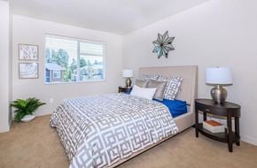 Snoqualmie townhouse for rent - A bedroom with a large bed and a window overlooking a house.
